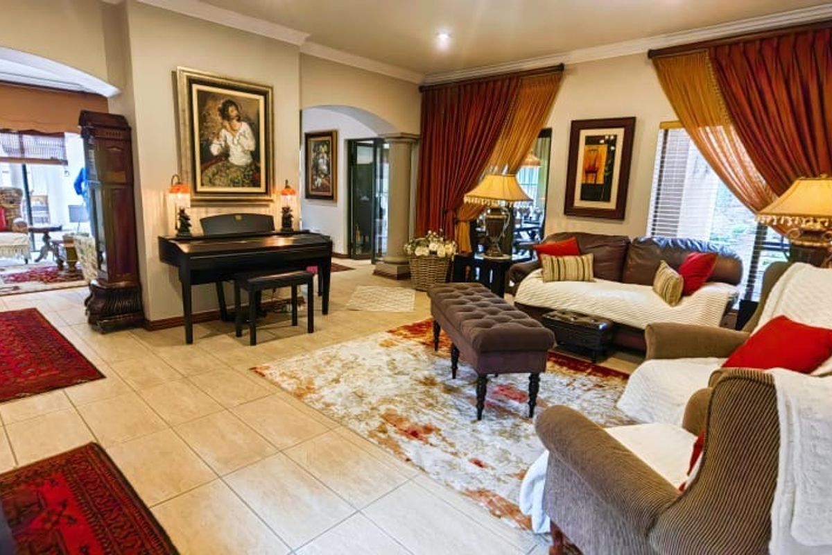 Spacious living room featuring tiled flooring, elegant archways, and recessed lighting, creating a warm and inviting atmosphere for relaxation and entertaining.