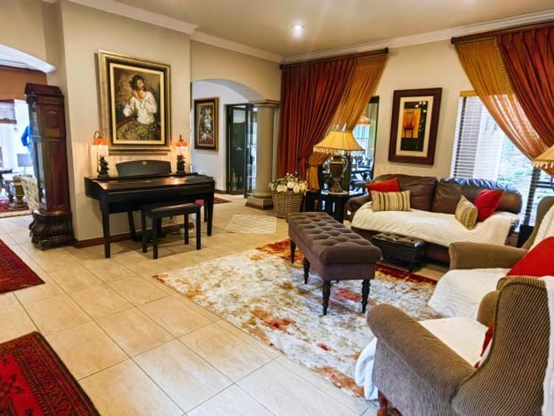 Spacious living room featuring tiled flooring, elegant archways, and recessed lighting, creating a warm and inviting atmosphere for relaxation and entertaining.