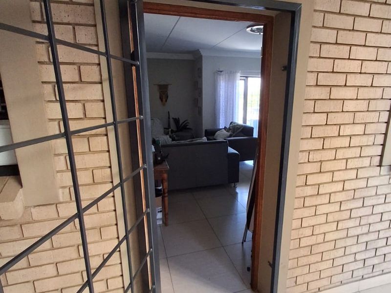 View of the apartment entrance featuring a security gate and brick exterior wall leading into the living area.