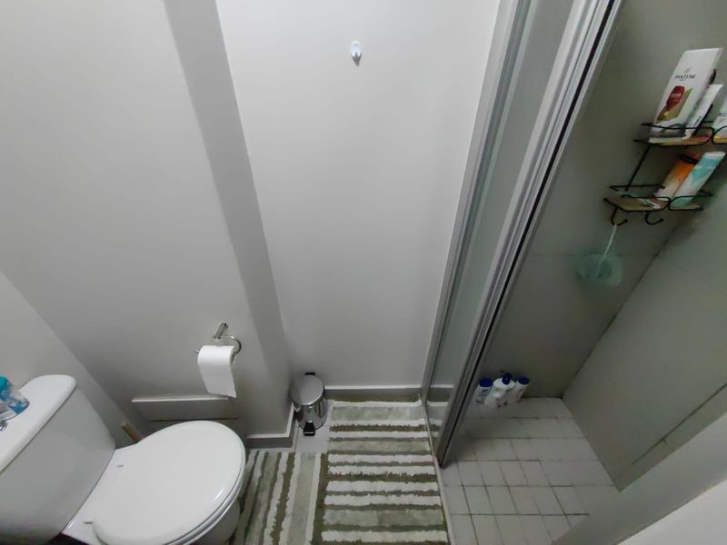 A functional bathroom featuring a standard toilet and a separate shower enclosure with tiled flooring.