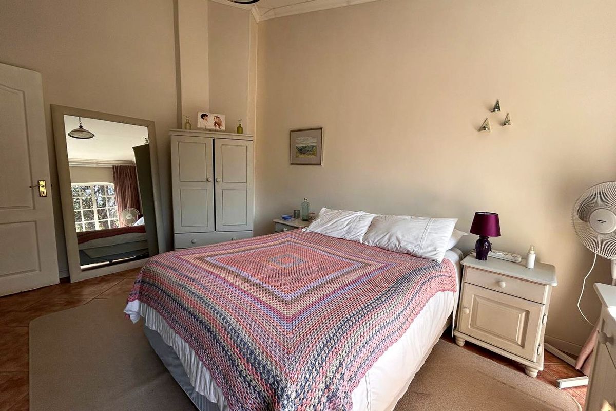 A well-proportioned bedroom featuring tiled flooring, decorative coving, and a built-in wardrobe, offering a comfortable and functional living space.