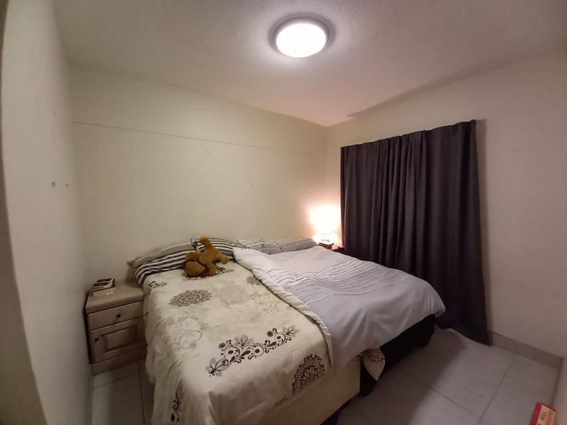 A compact bedroom featuring tiled flooring and a central ceiling light fixture, requiring minor cosmetic updates to the wall finishes.