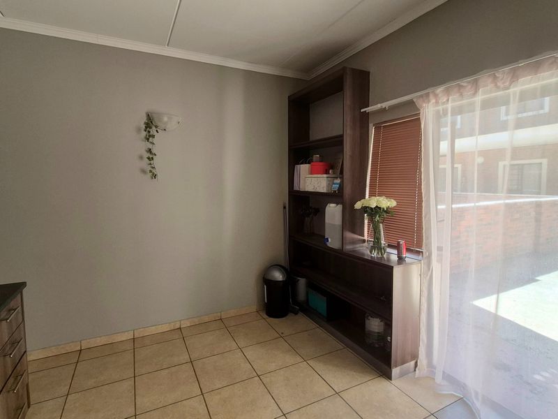 A kitchen area featuring tiled flooring, a built-in shelving unit, and a sliding glass door providing access to the exterior.