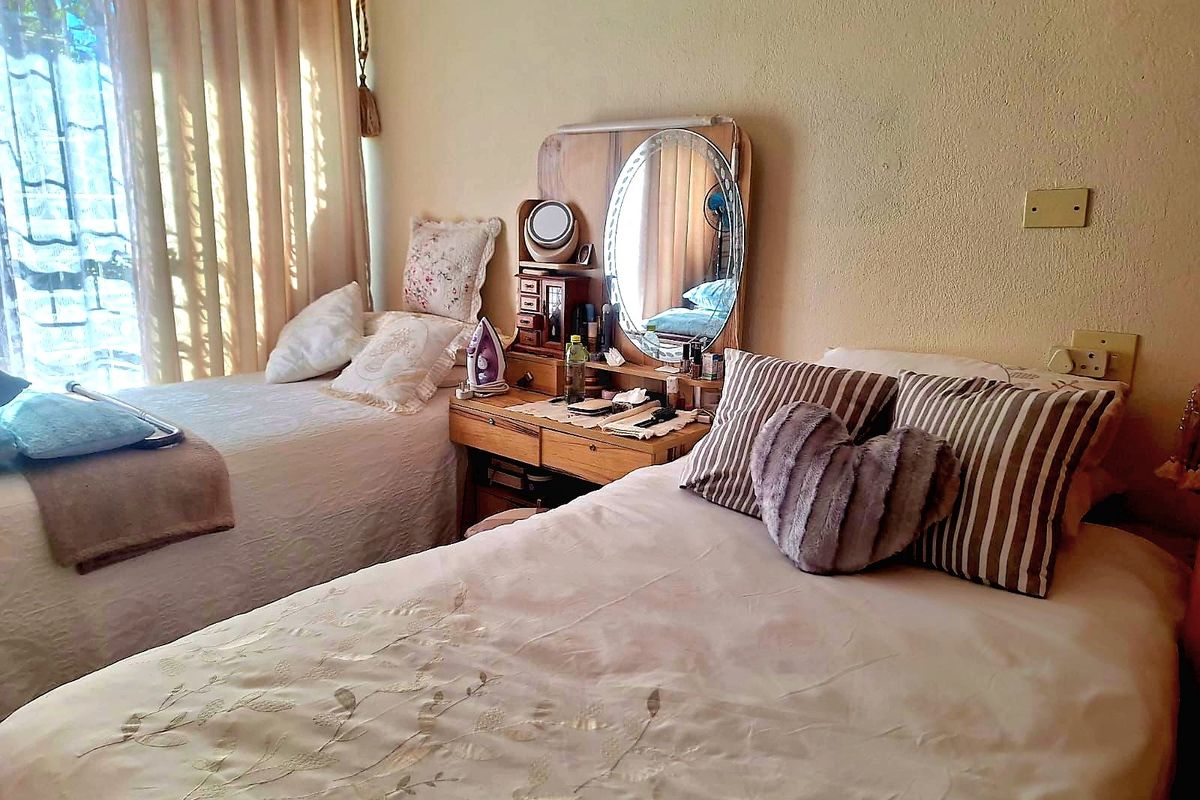 A bedroom featuring a sliding glass door with curtains, neutral wall finishes, and standard electrical fixtures.