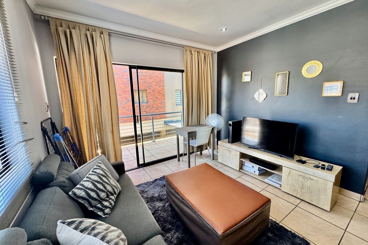 A living room featuring tiled flooring, recessed lighting, and a sliding glass door providing direct access to an outdoor balcony.