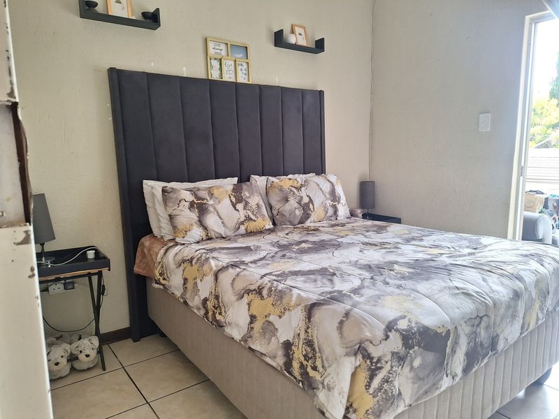 A bedroom featuring tiled flooring and a sliding door providing access to an outdoor area.