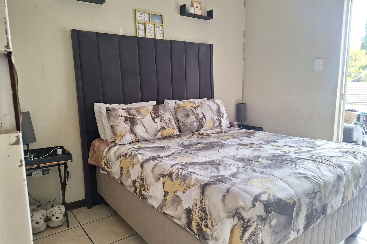 A bedroom featuring tiled flooring and a sliding door providing access to an outdoor area.