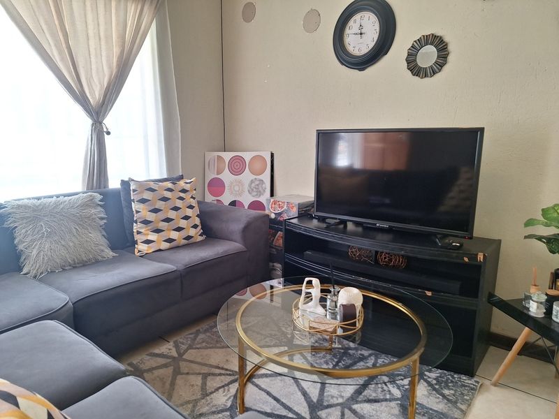 A cozy living room area featuring neutral wall finishes and natural light through window treatments.