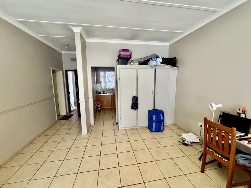 Open plan living area featuring ceramic floor tiles, built-in storage, and a view through to the kitchen area.