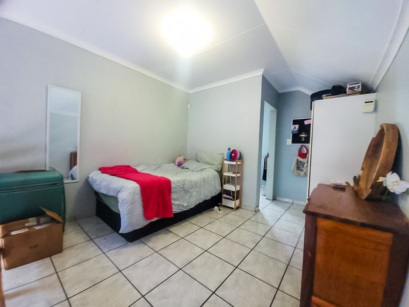 A bedroom featuring tiled flooring and coved ceilings, providing a functional living space with neutral wall finishes.