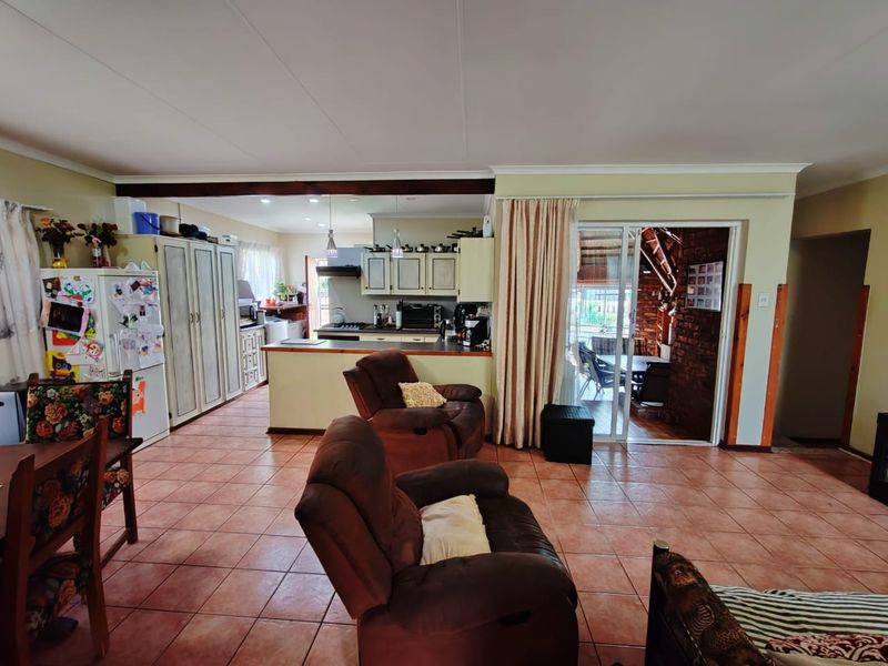 Open plan living and kitchen area featuring tiled flooring, built-in cabinetry, and direct access to an outdoor patio through sliding glass doors.