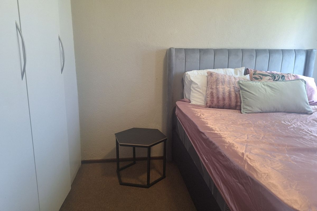 A bedroom featuring a built-in wardrobe with white doors and neutral wall finishes.
