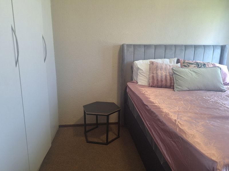 A bedroom featuring a built-in wardrobe with white doors and neutral wall finishes.