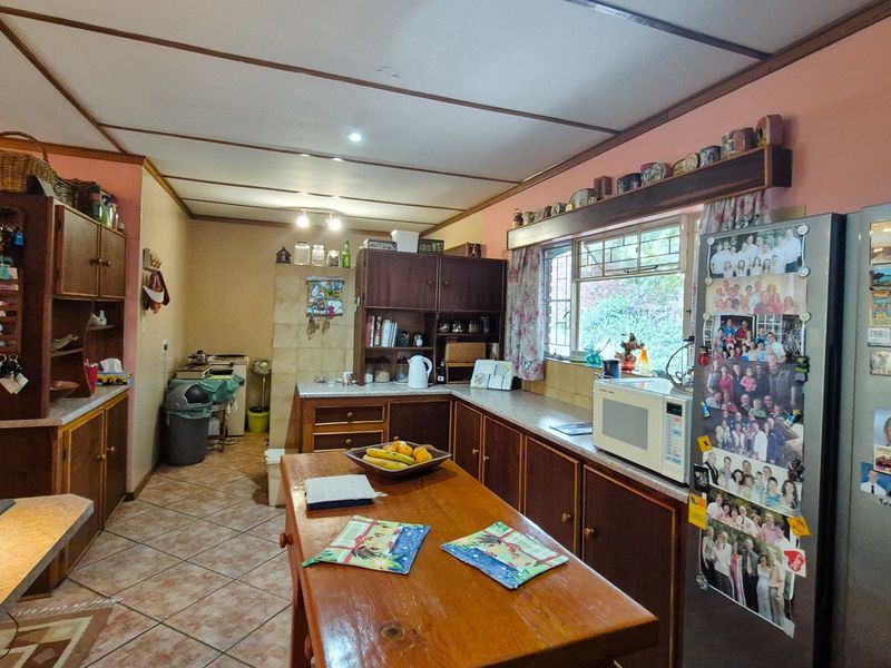 A dated kitchen featuring wooden cabinetry, tiled flooring, and laminate countertops, offering a functional layout with potential for modern renovation.