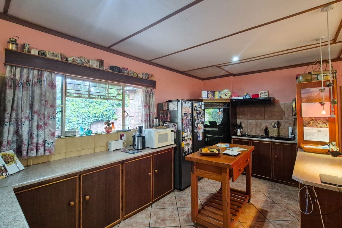 A functional kitchen featuring dark wood cabinetry, tiled backsplash, and tiled flooring, offering a traditional layout with ample counter space.