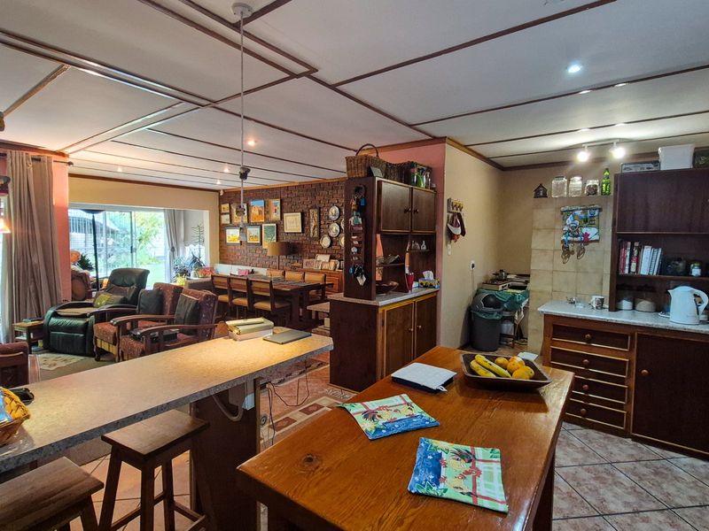 Spacious open-plan living and kitchen area featuring exposed brickwork, built-in cabinetry, and direct access to the garden through sliding glass doors.