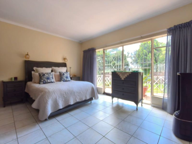 Spacious bedroom featuring tiled flooring and large sliding glass doors that provide direct access to the garden area.