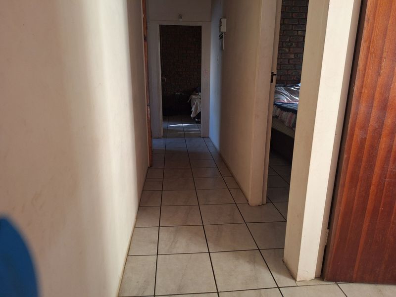 A functional hallway with tiled flooring providing access to adjacent rooms.