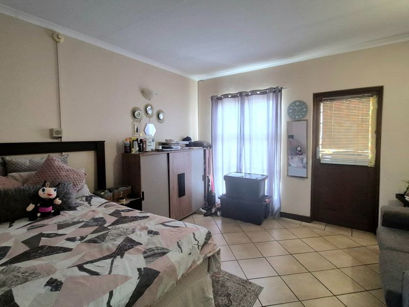 A bedroom featuring tiled flooring, coving, and direct access to an exterior area through a private door.