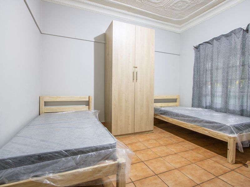 A bedroom featuring tiled flooring and a decorative pressed metal ceiling with cornice detailing.