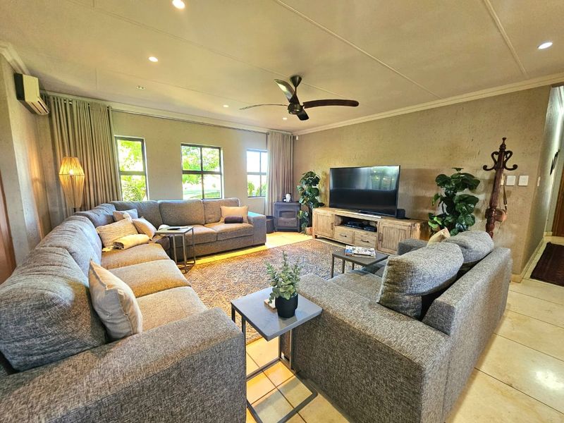 Spacious living room featuring tiled flooring, recessed lighting, a ceiling fan, and a built-in fireplace, creating a comfortable and functional family space.