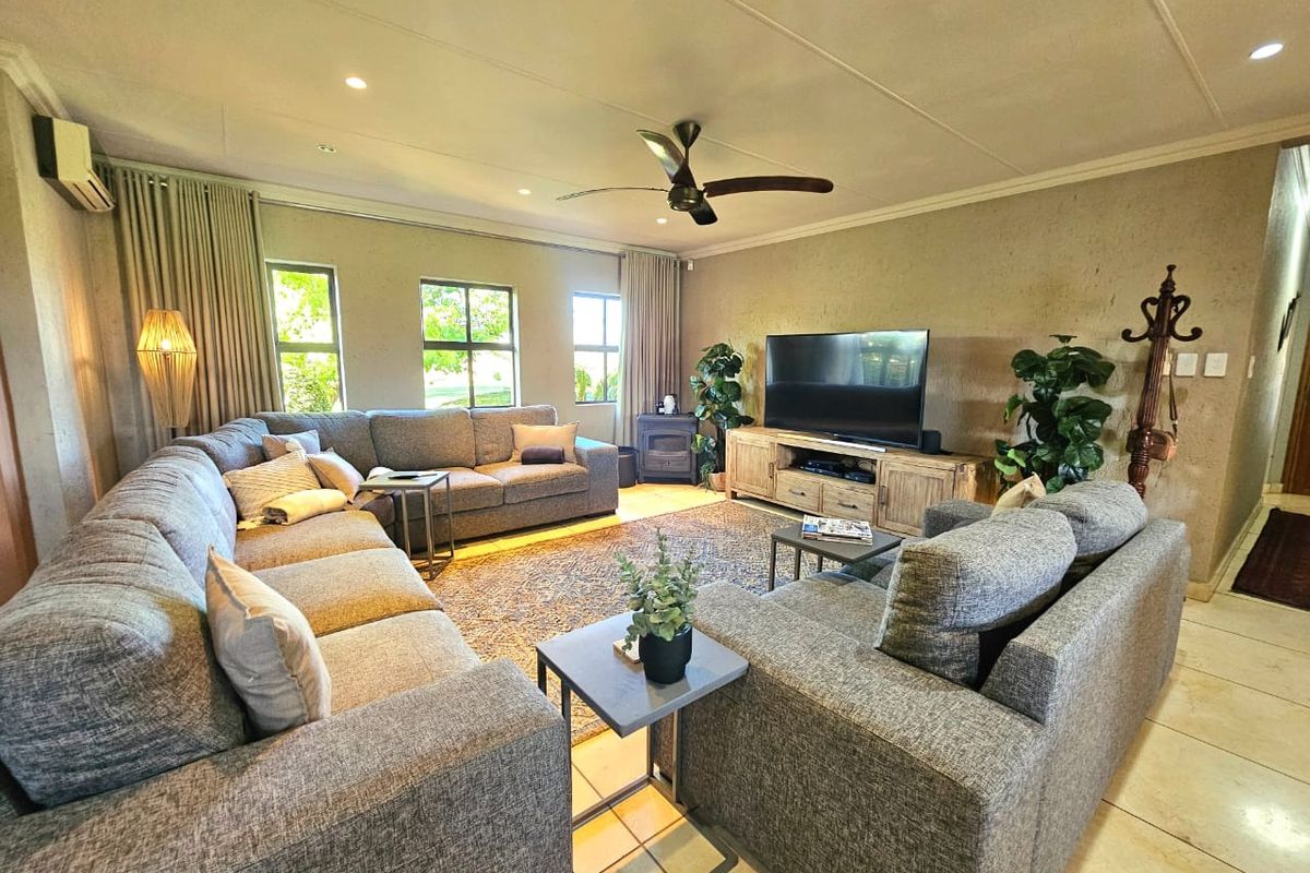Spacious living room featuring tiled flooring, recessed lighting, a ceiling fan, and a built-in fireplace, creating a comfortable and functional family space.