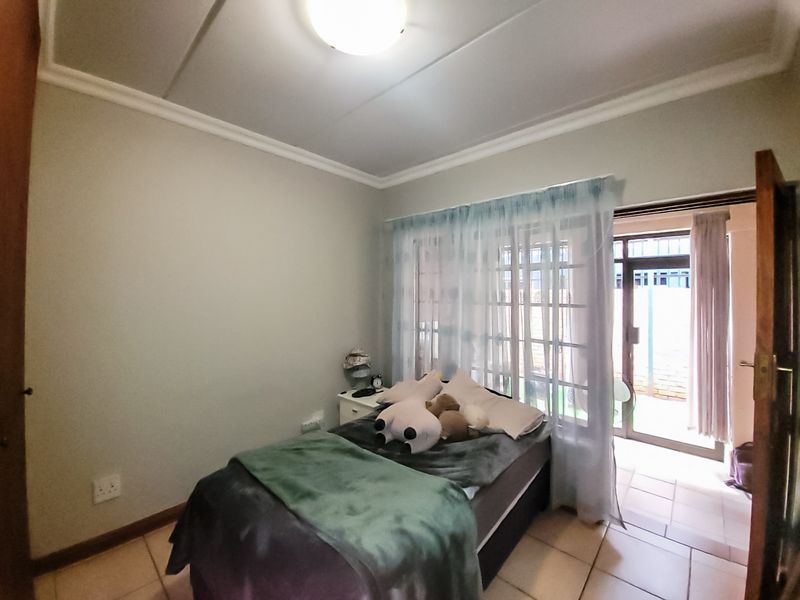 A bedroom featuring tiled flooring and a sliding glass door providing access to an outdoor area.