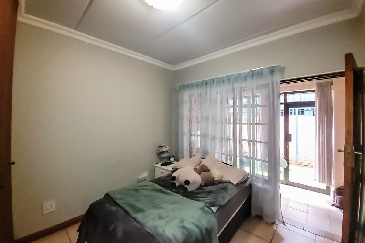 A bedroom featuring tiled flooring and a sliding glass door providing access to an outdoor area.