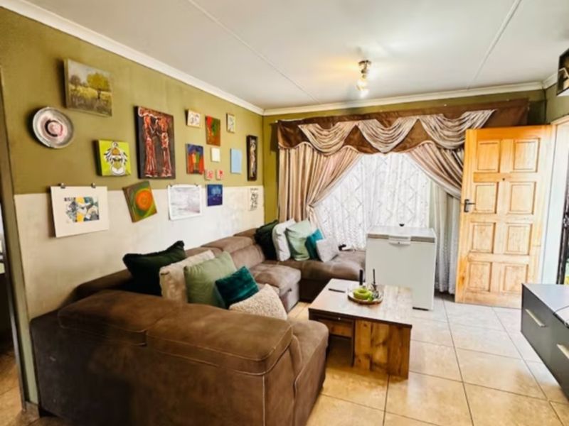 A living room featuring tiled flooring, a timber panel door, and decorative ceiling cornicing, providing a functional space for relaxation.
