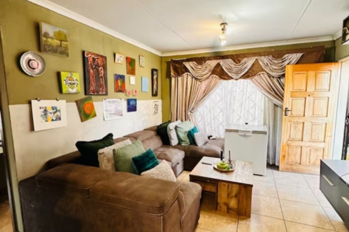 A living room featuring tiled flooring, a timber panel door, and decorative ceiling cornicing, providing a functional space for relaxation.