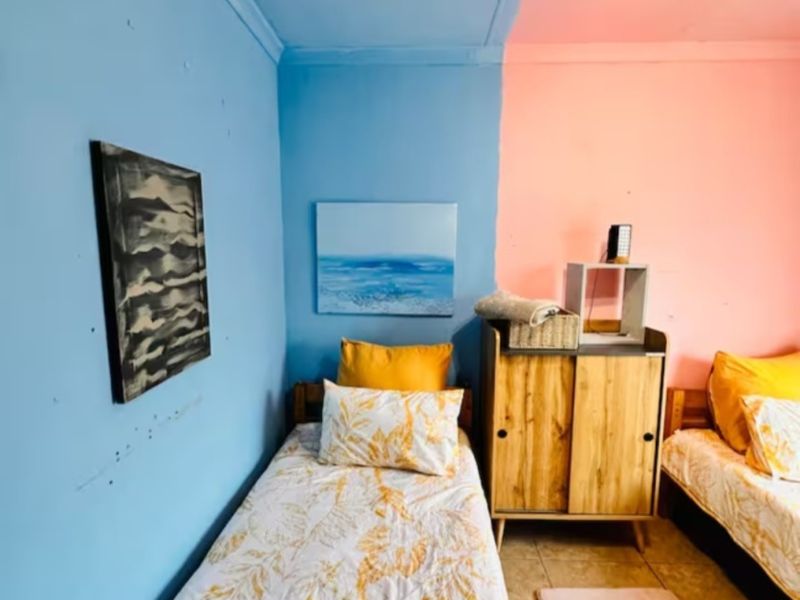 A bedroom featuring tiled flooring and a dual-tone painted wall finish, requiring minor cosmetic updates to improve the overall aesthetic.
