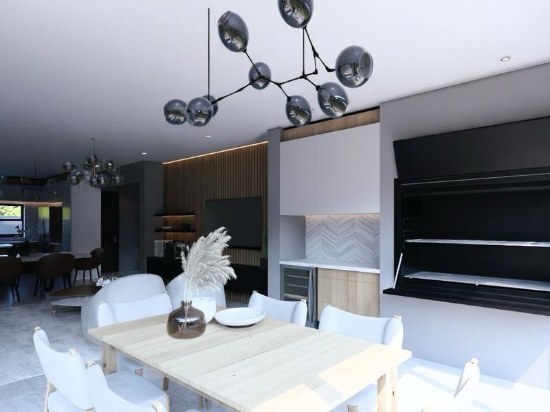 Modern open-plan living area featuring a built-in braai, wine cooler, stylish timber wall accents, and contemporary pendant lighting, perfect for seamless indoor entertaining.