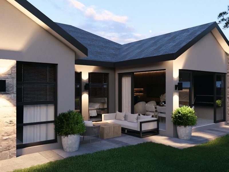 A modern rear exterior view featuring a covered patio, stone wall accents, and large sliding glass doors leading into the home's living space.