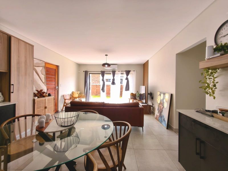 Spacious open-plan living and dining area featuring modern tiled floors, built-in cabinetry, and large sliding doors leading to the exterior.