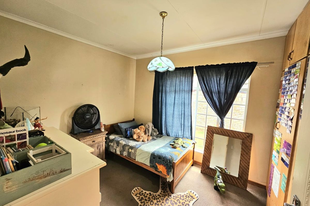 A standard bedroom featuring a built-in wardrobe, neutral wall finishes, and a window providing natural light.