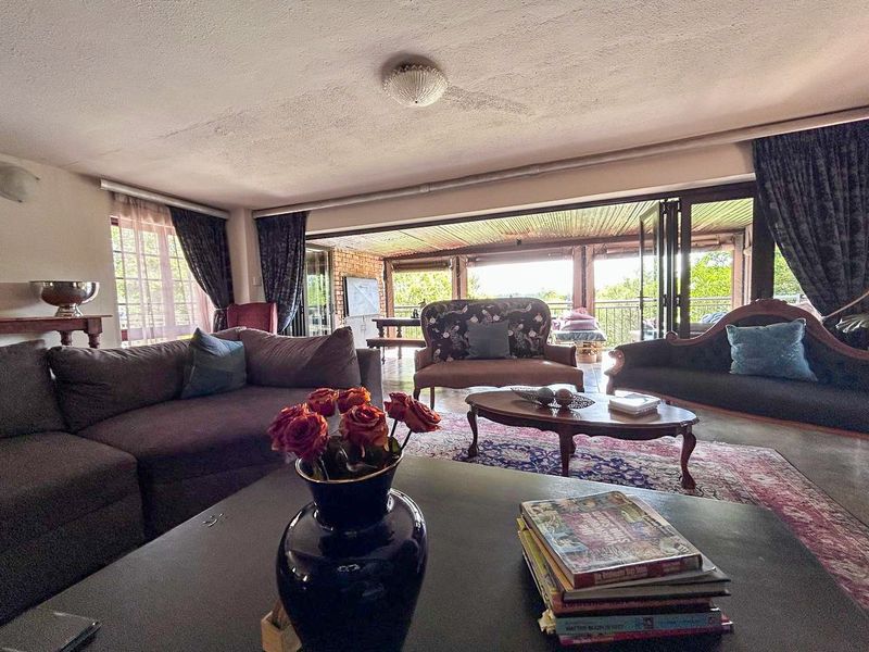 Spacious living room featuring large bi-fold doors that open onto a covered patio, providing seamless indoor-outdoor flow and natural light.