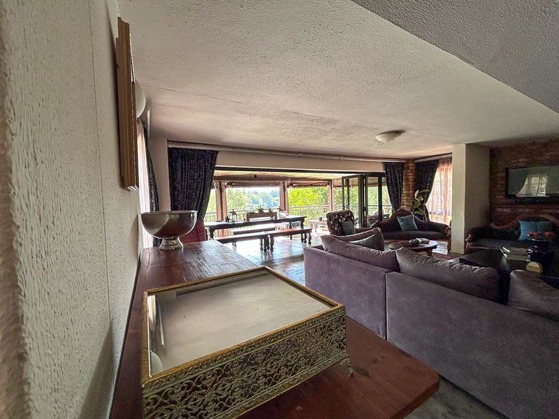 Spacious open-plan living area featuring exposed brick accents, textured ceilings, and large sliding glass doors that open onto an outdoor patio space.