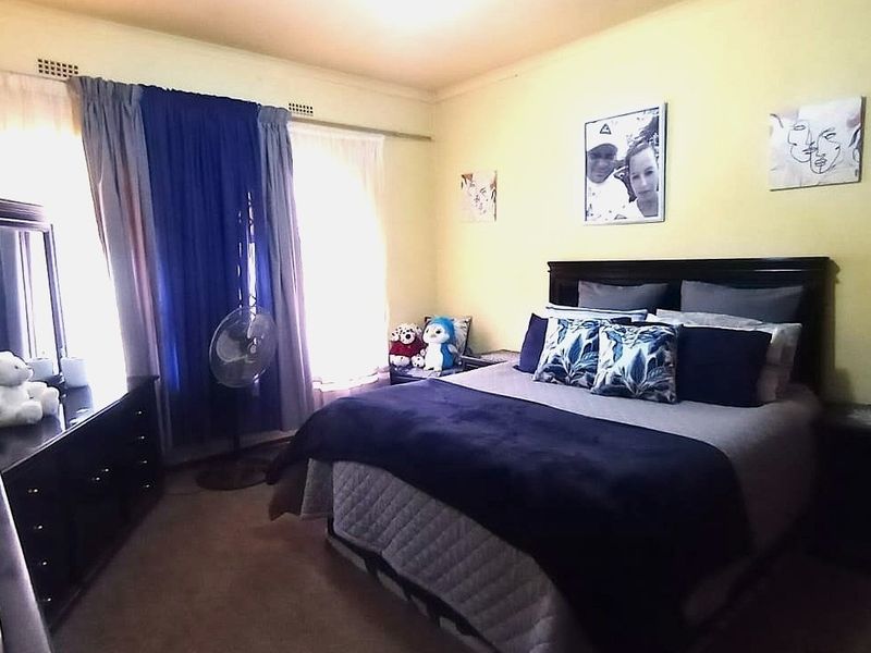 A standard bedroom featuring carpeted flooring and curtain rails, providing a functional space for rest.