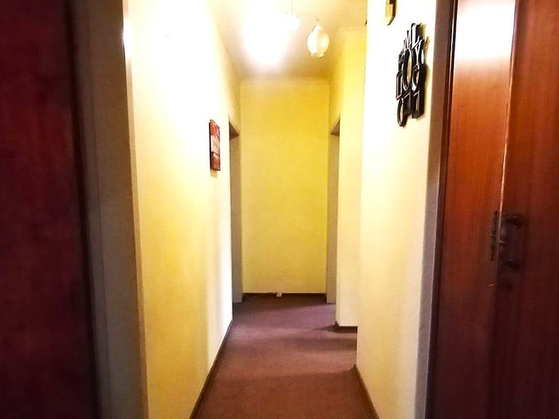 A functional interior hallway featuring built-in wooden cabinetry and access to multiple rooms.