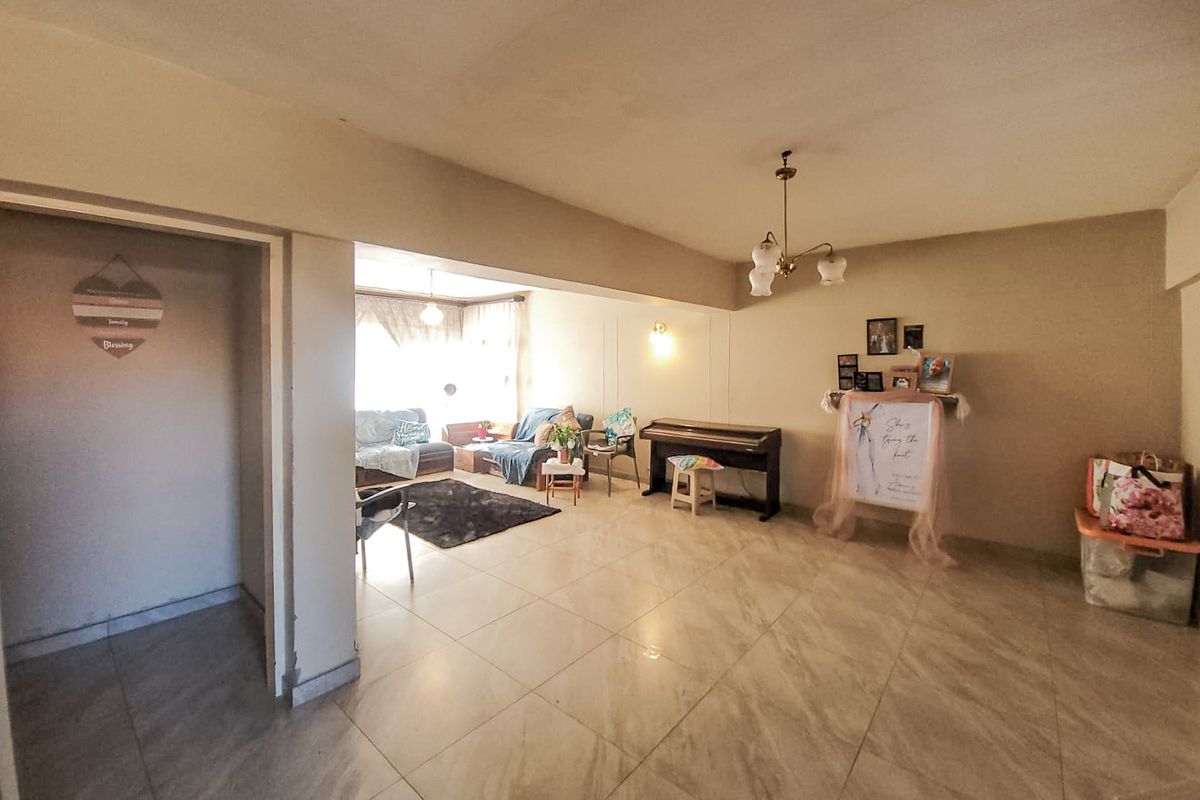 Spacious living area featuring neutral tiled flooring and integrated lighting, offering a versatile open-plan layout suitable for various furniture arrangements.