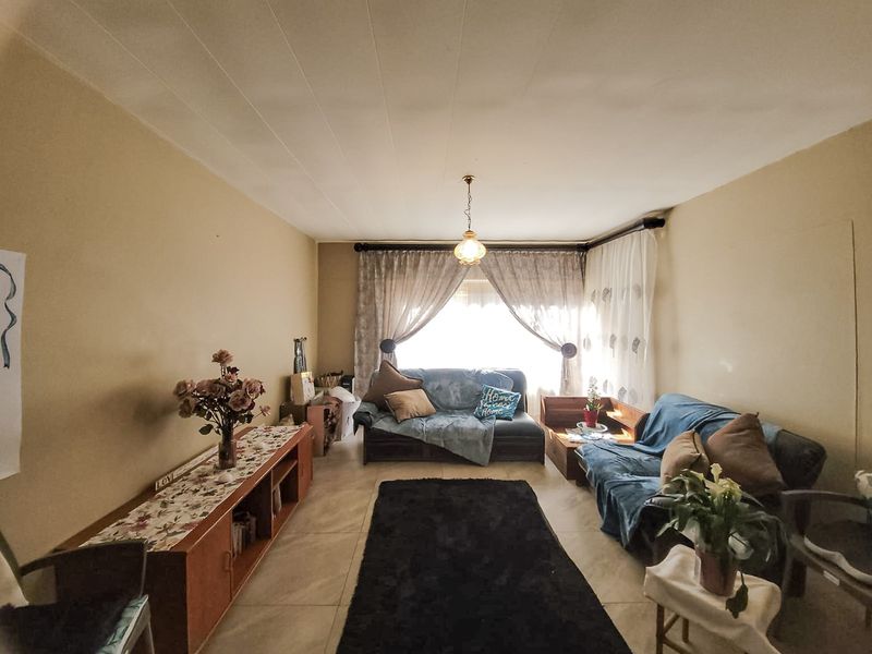 A living room featuring tiled flooring and neutral wall tones, offering a functional space ready for modern updates and personal styling.