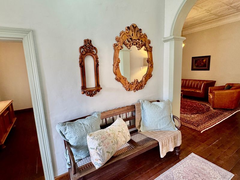 Welcoming entrance hall featuring classic archway architecture, rich hardwood flooring, and decorative ceiling molding, leading into the main living area.