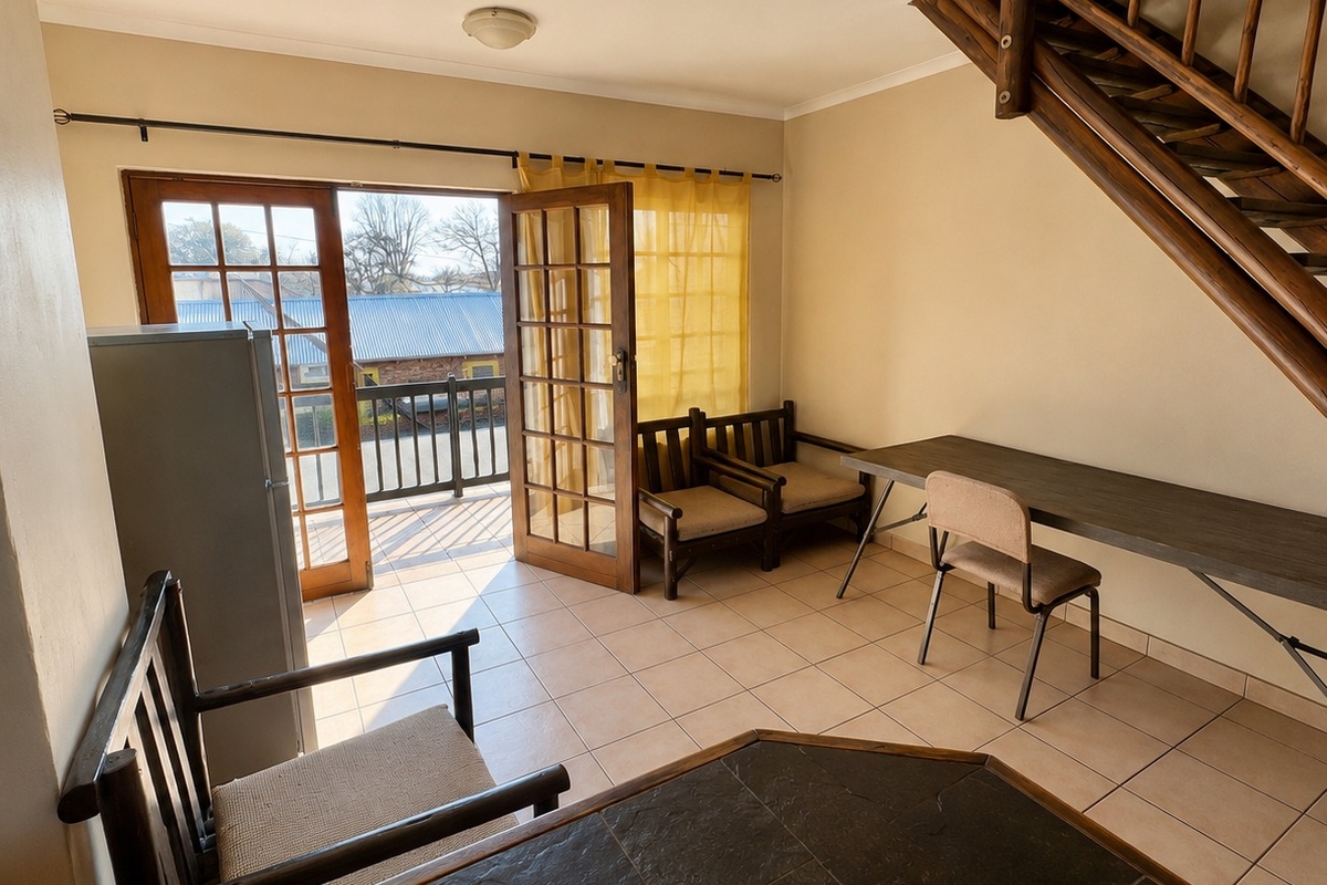 Living area featuring tiled flooring, a wooden staircase, and double glass doors providing direct access to an outdoor balcony.