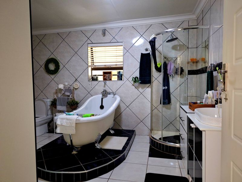 A well-appointed bathroom featuring a classic clawfoot bathtub on a raised platform, a separate corner shower, and a modern vanity basin.