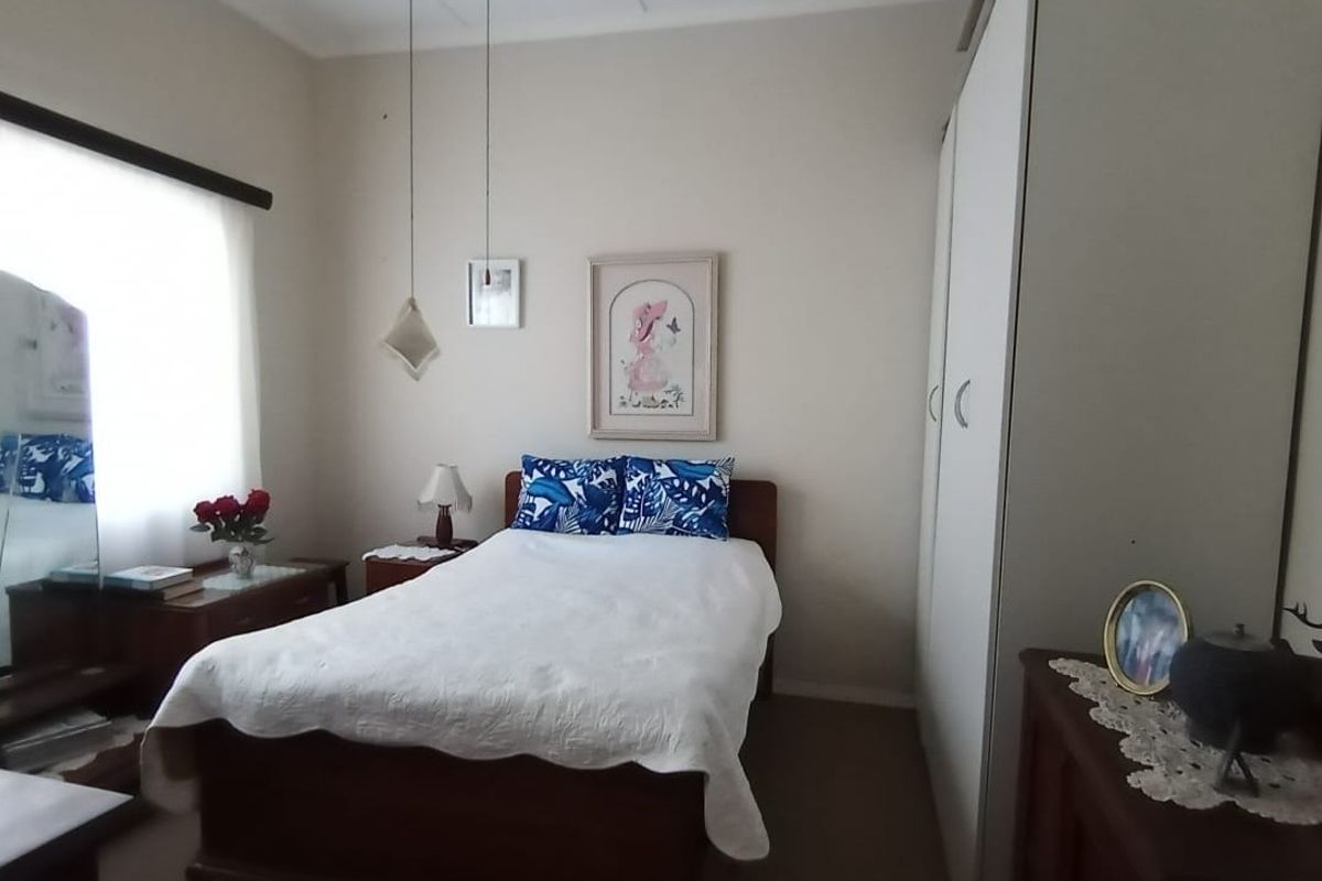 A functional bedroom featuring a built-in wardrobe and neutral wall finishes, offering a comfortable and practical living space.