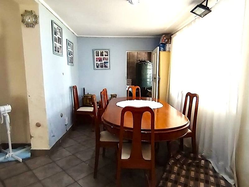 A dining room featuring tiled flooring and a large window, providing natural light to the space.