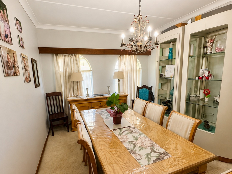 A formal dining room featuring arched windows, built-in display cabinetry, and a decorative chandelier, providing a classic space for family meals and entertaining.