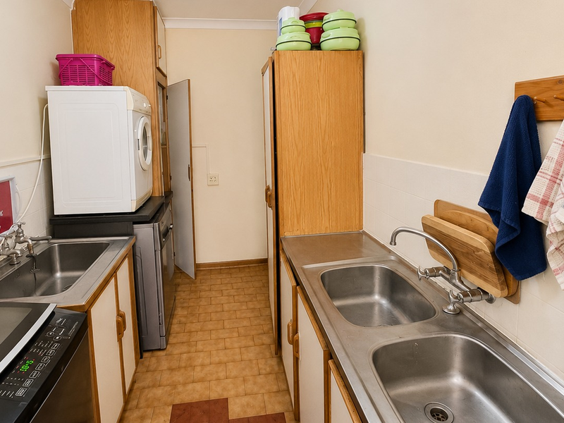 Functional laundry area featuring dual stainless steel sink stations, ample built-in cabinetry, and durable tiled flooring.