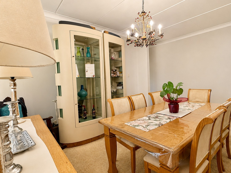 A formal dining room featuring a decorative chandelier and classic cove cornicing, providing a traditional space for family meals and entertaining.
