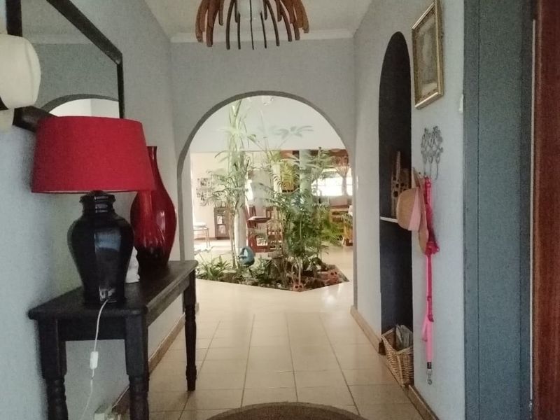 A welcoming entrance hallway featuring tiled flooring and a decorative archway leading into the main living area of the home.